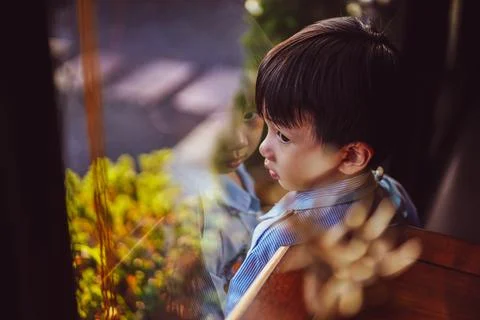 Kid looking out window.  Фото