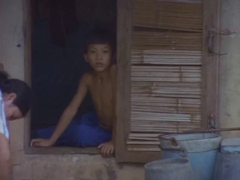 Kid looking out of a window sill staring at the camera Vídeos de archivo 79880650
