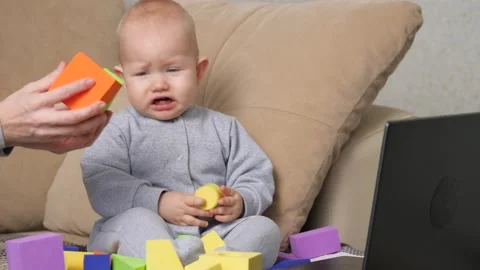 The kid looks at the computer, is naughty, crying. Mom teaches her little child Stock Footage 161851515