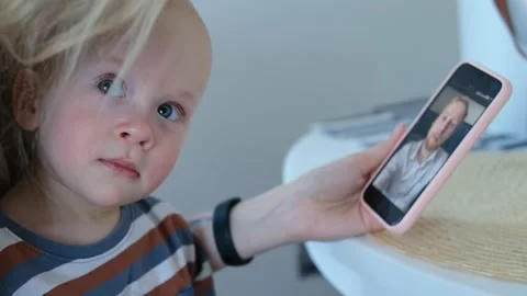 Kid looks at dad on the smartphone screen Video stock 152552546