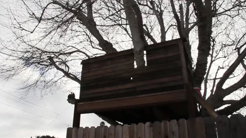 Kid looks at tree house from the other side of the fence Stock Footage 155386026