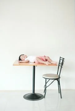 Kid lying on wrong place. Somebody put baby boy on the dining table Fotos Stock