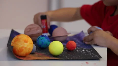 Kid making a 3D solar system on a list of paper Stock Footage 165679821