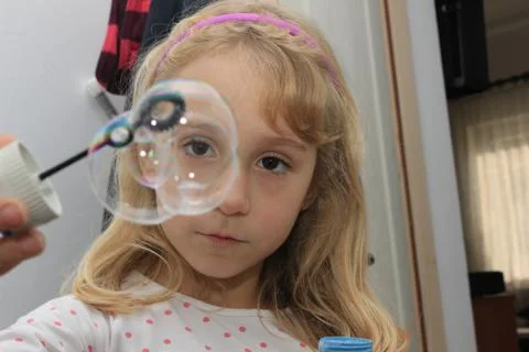 Kid making balloon from soap Foto stock