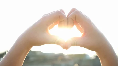 Kid making heart hands against the blue sky, child hands forming a heart shape. Stock Footage