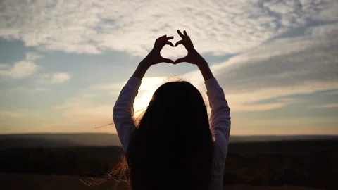 Kid making heart hands against the blue sky, child Stock Footage 236257441