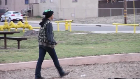 Kid with mask up walks thru playground Stock Footage 155490621