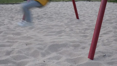 Kid moves sand while swinging in slow motion, 60 fps Video stock 129717482
