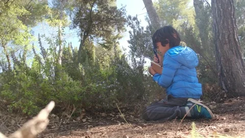Kid naturalist seated down explores the life of plants and insects Stock Footage 238368298