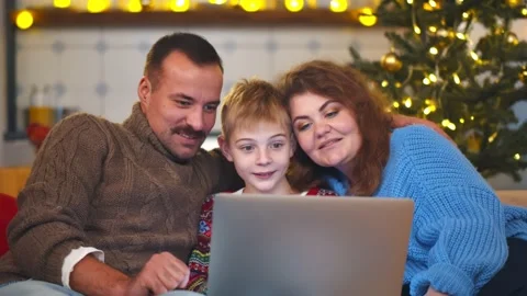 Kid with parents using laptop in decorated living room on christmas eve Stock Footage 144109733