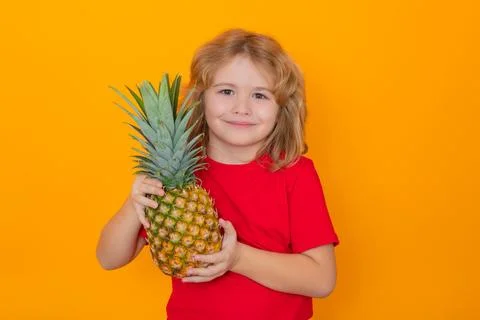 Kid with pineapple in studio. Studio portrait of cute child hold pineapple Stock Photos