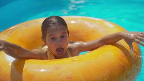 Kid play on inflatable ring in the pool.... | Stock Video | Pond5