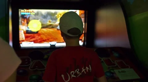 Kid playing arcade video game at an amusement park Stock Footage 45666058