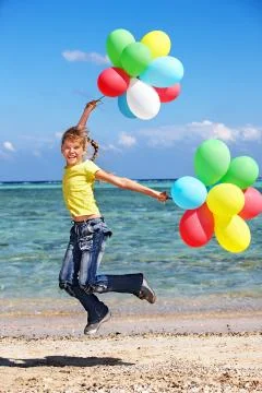 Kid playing with balloons at the beach Stock-Fotos