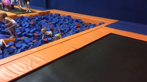 Kid playing in blue foam pit with orange borders Stock Footage 74504375
