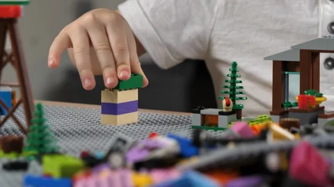 Kid is playing with building bricks, closeup hands. Educational Building Blocks  Stock Footage 123964440