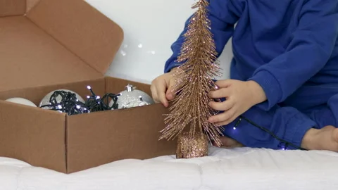 Kid playing with christmas tree balls inside home 스톡 동영상 223510918
