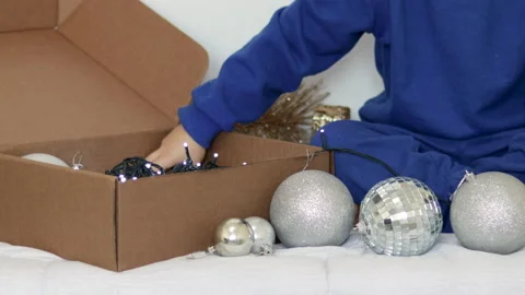 Kid playing with christmas tree balls inside home Видео 223511243