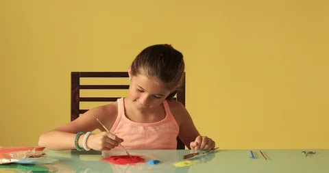Kid Playing With Colorful Sand &amp; Tools On Glass Table Against Yellow Background Видео 122771202