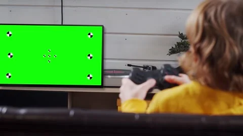 Kid playing console video game using tv with chroma key green screen Stock Footage 267420354