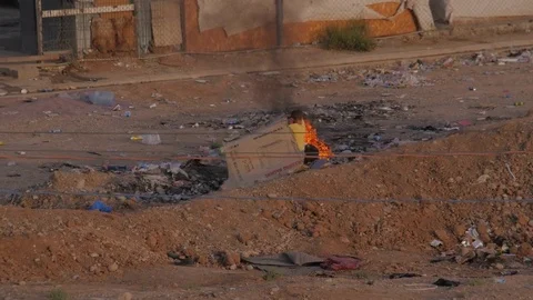 Kid playing with fire out of a refugee camp in Erbil - Iraqi Kurdistan Stock-Footage 75907501