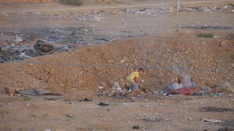 Kid playing with fire out of a refugee camp in Erbil - Iraqi Kurdistan 스톡 동영상 75907721