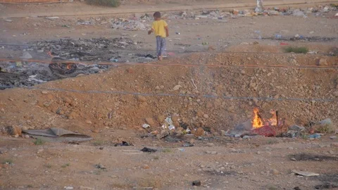 Kid playing with fire out of a refugee camp in Erbil - Iraqi Kurdistan Stock-Footage 75907843