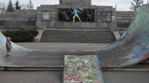 Kid playing in front of a Soviet monument in Sofia painted in colours of Ukraina Stock Footage 35527896