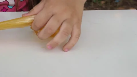 Kid Playing Hand Made Toy Called Slime. cute girl plays with a yellow slime Stock Footage 167314668