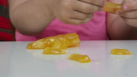 Kid Playing Hand Made Toy Called Slime. cute girl plays with a yellow slime 動画素材 167314912