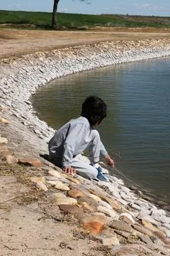Kid playing at lake shore exploring nature 스톡 사진