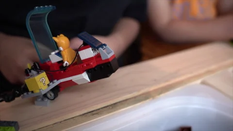 Kid playing lego building blocks, kid building an airplane with toys. Stock Footage 262357043