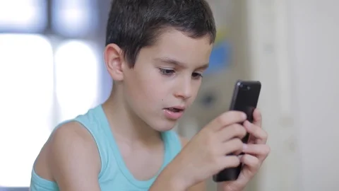 Kid playing mobile game on smartphone at home Stock Footage 111970541