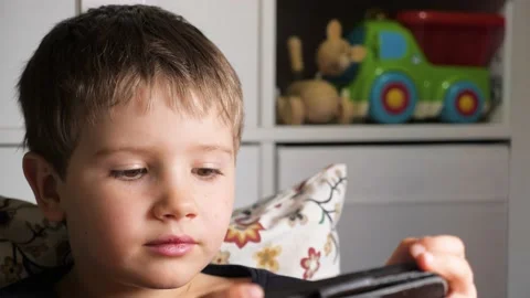 Kid playing mobile game on smartphone. Boy using phone for gaming. Child playing Stock Footage 145862577