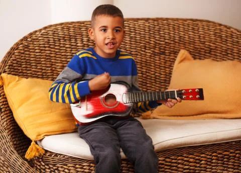 Kid playing musical instruments Stock Photos