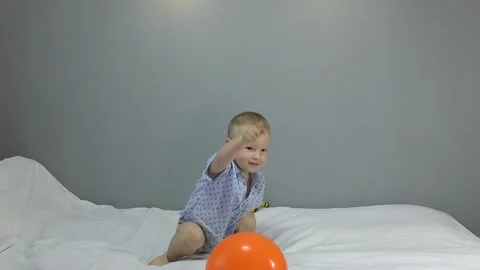 Kid playing with an orange ball Stock Footage 139181412