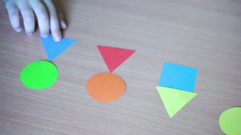 Kid playing with paper geometric shapes and making different cute human figures Stock Footage 226029980