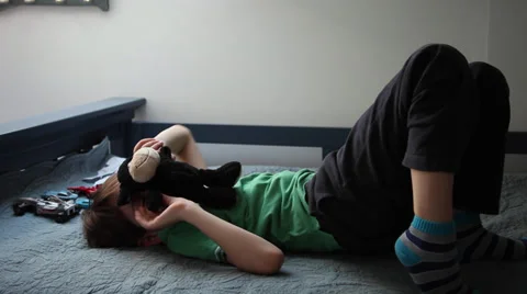 Kid playing peek a boo with a plush toy, child hides his face, boy lying on back Stock Footage 37387706