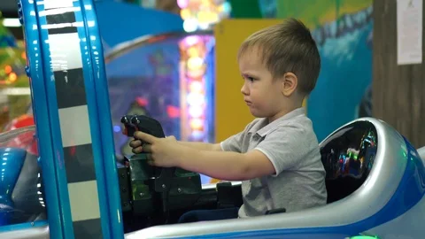 Kid playing on a plane simulator in theme park. Stock Footage 98507896