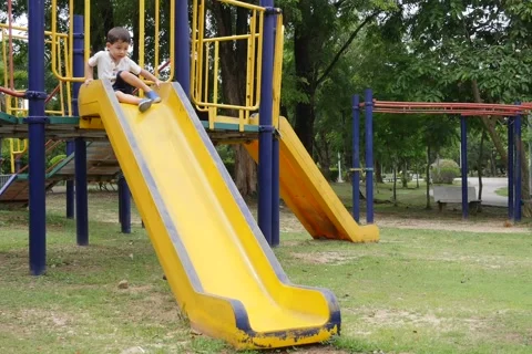 A Kid Playing on a Public Park Slide Stockbeeldmateriaal 65008049