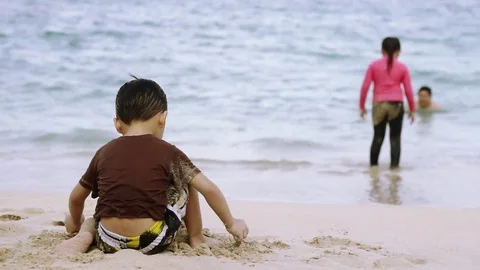 Kid playing with sand on beach Vídeo Stock 79312735
