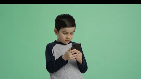 Kid playing with smart phone - green screen alpha channel lifestyle boy isolated Stock Footage 128989986