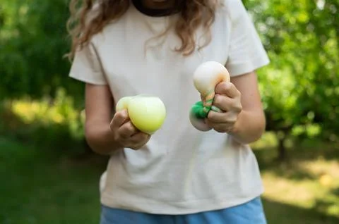 Kid playing with two cute dumpling squishy toys in hands Stock Photos