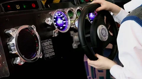 Kid playing in video car simulator in game center Stock Footage 52437231