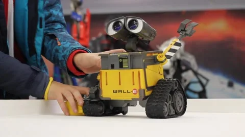 Kid playing with WALL-E. Robot toy character form WALL-E animation film by Disne Stock Footage