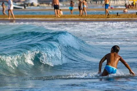 Kid playing with waves during summer Stock Photos