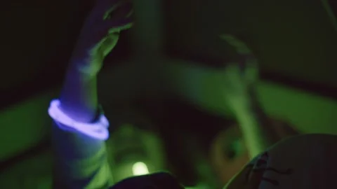 The kid plays with 2 glow violet round-shaped sticks Video stock 130316019