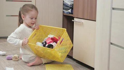 The kid plays about and throws his things out of the box. A child in pajamas Stock Footage 148088556
