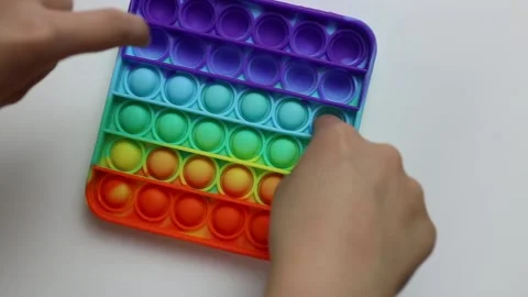 Kid plays with anti-stress toy pop it, simple dimple on white background. Pre Stock Footage 155520853