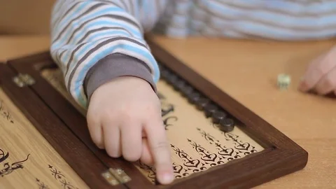 Kid plays Backgammon. little hands play chip. Stock Footage 75417253